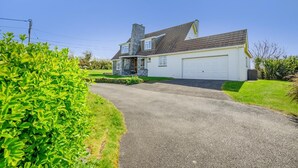 A two-story house with a garage, a driveway, and a well-maintained lawn. - 4 Bed in Harlyn Bay (oc-t35030) (Harlyn Bay)