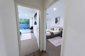A bedroom with a bed, bedside table, and a view of the backyard. - 47A Westlake Road Morley is a Perfect 4-bedroom house with AC in gorgeous Morley (Morley)