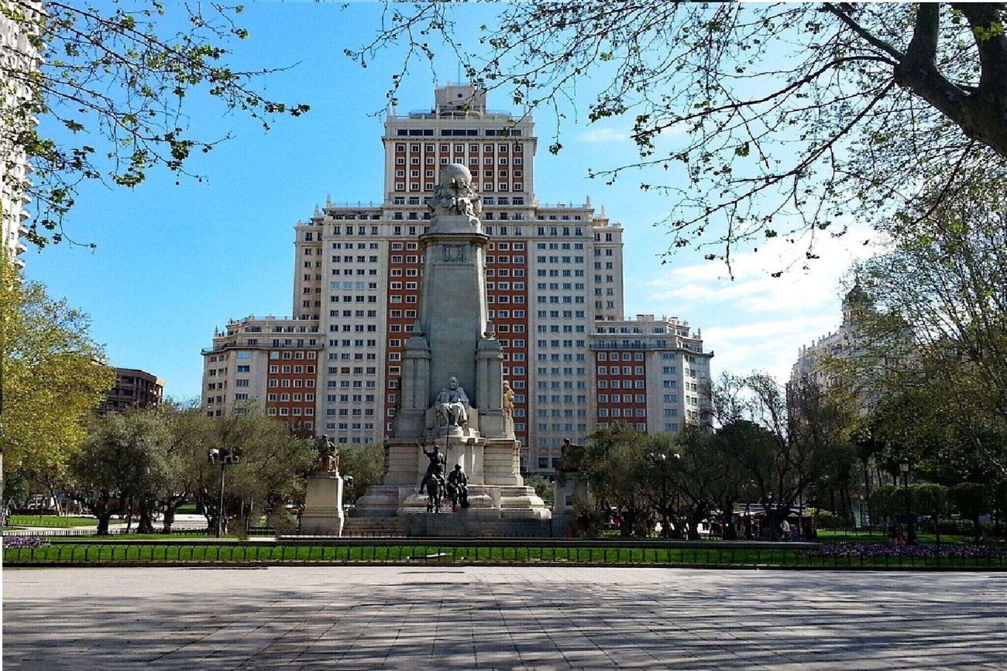 A large building with a central monument in a park.