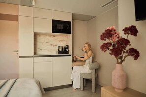 A compact kitchen with a microwave, coffee maker, and a small cabinet. - Persante Sunrise Collection 11 | Riverview | AC (Kołobrzeg)