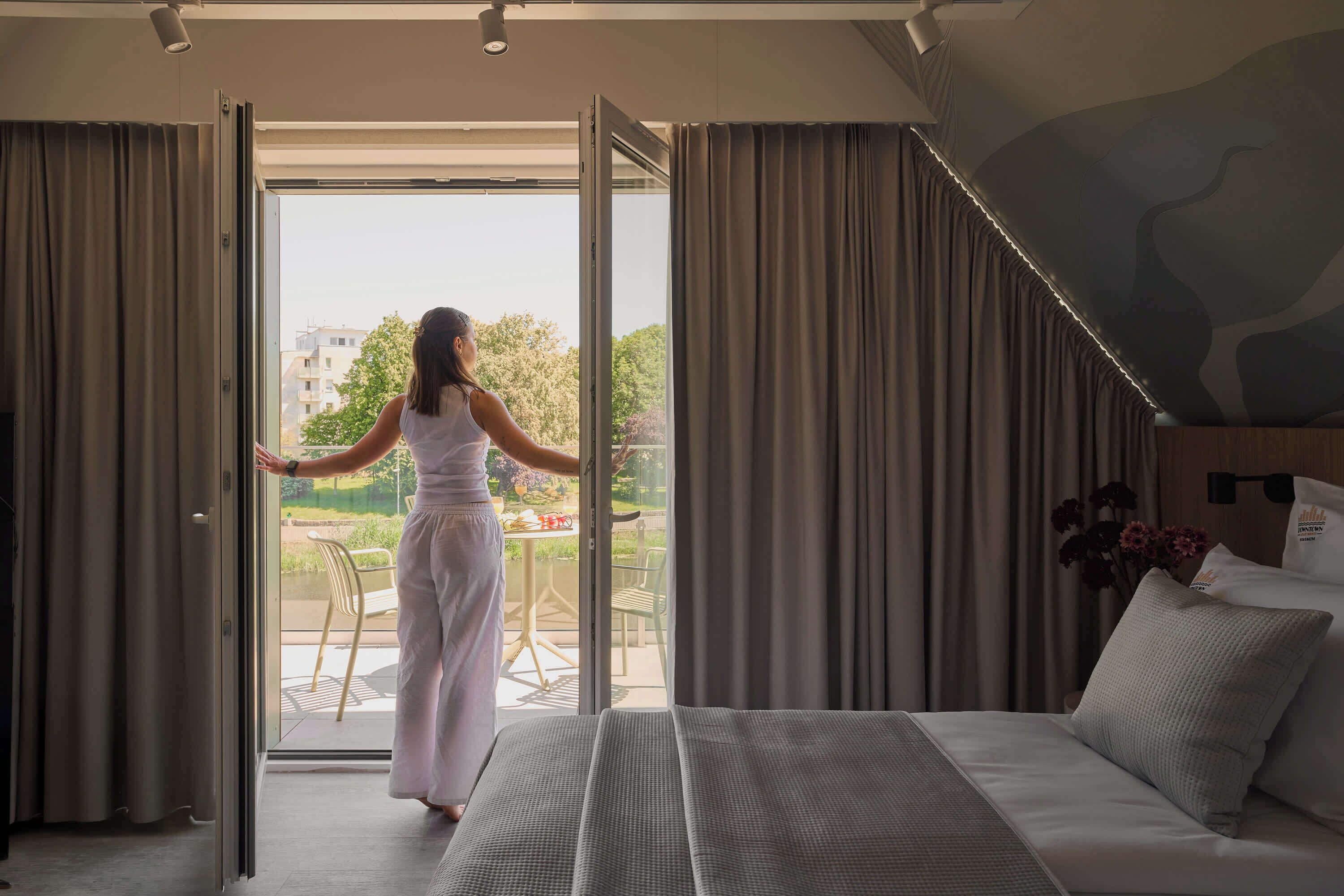Un dormitorio con cama, cortinas y vistas a un patio exterior.