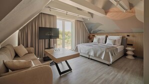 Une chambre d’hôtel moderne équipée d’un lit, d’un canapé, d’une télévision et d’une table à manger.