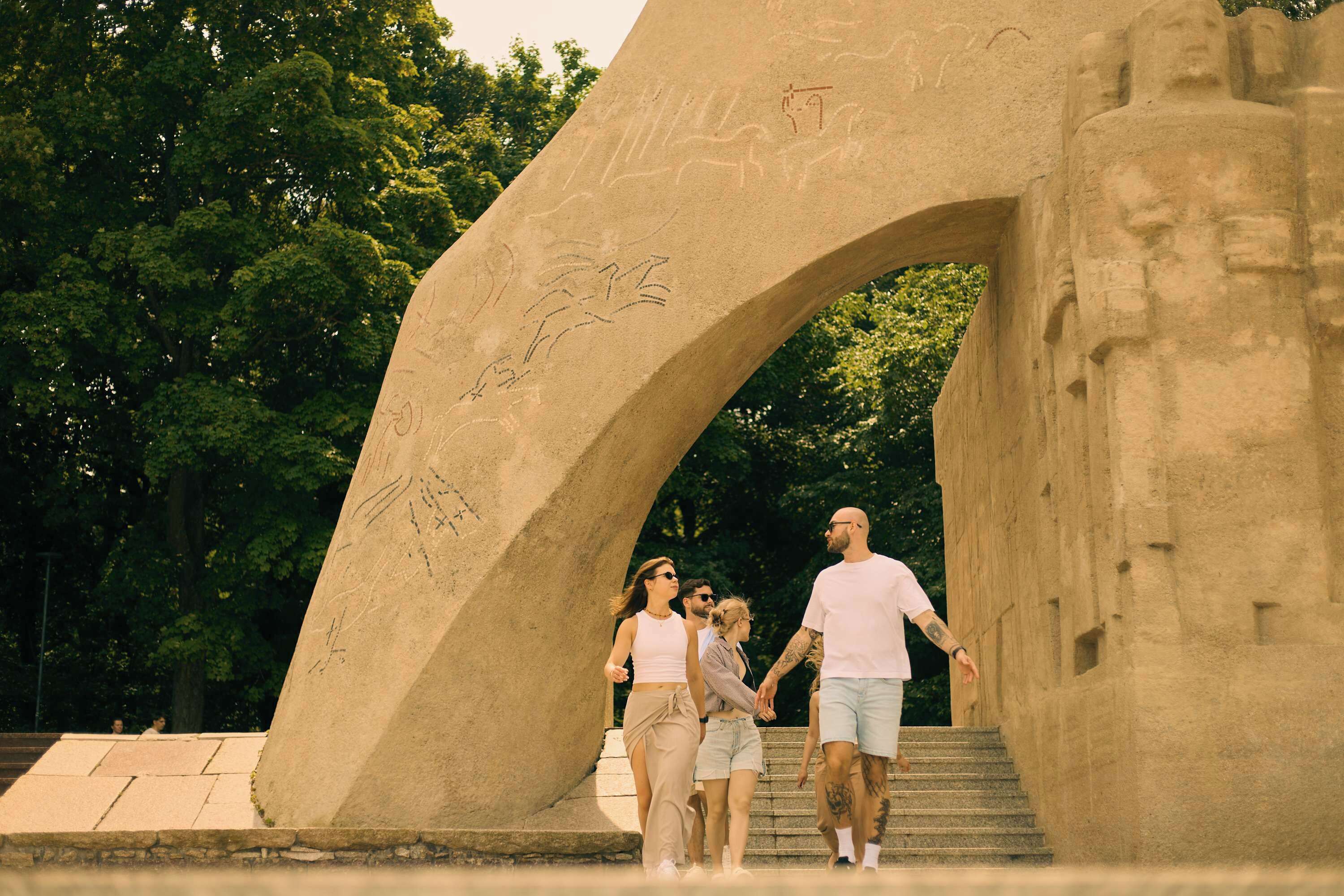 A large stone archway with carvings, leading to a set of stairs.