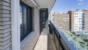 A balcony with a view of a sports court and surrounding buildings. - 6-Guest Haven near Golden Mile (Madrid)