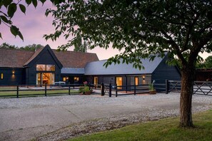A modern building with multiple rooms, a gravel driveway, and a tree in the foreground. - 6 Bed in Ardleigh (oc-b35089) (Ardleigh)