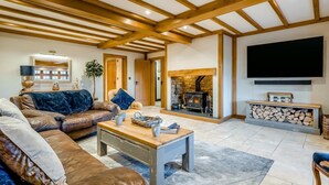 A living room with a fireplace, a television, and a sofa. - 4 Bed in East Dean (oc-l34384) (East Dean)