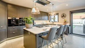 A modern kitchen with a central island, stainless steel appliances, and pendant lighting. - 4 Bed in East Dean (oc-l34384) (East Dean)