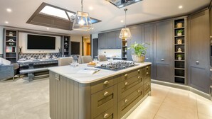 A modern kitchen with a central island, pendant lighting, and built-in shelving. - 4 Bed in East Dean (oc-l34384) (East Dean)