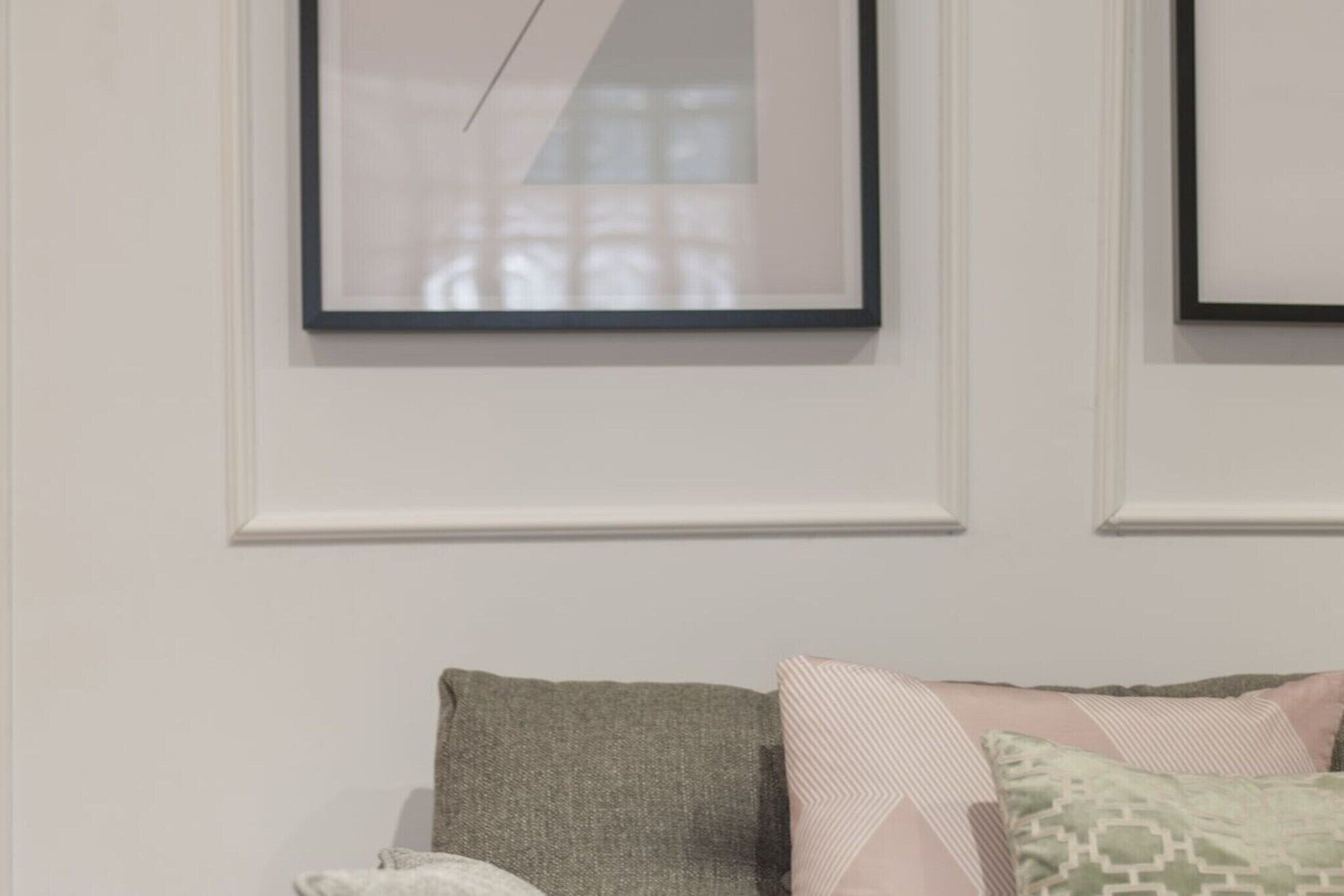 A room with a bed, a framed picture on the wall, and a window.