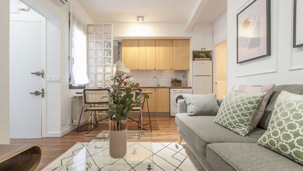 Ein modernes Wohnzimmer mit einer Couch, einem Couchtisch und einem Essbereich mit Stühlen.