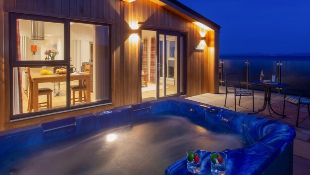 Ein modernes Gebäude mit Whirlpool und Sitzbereich im Freien.