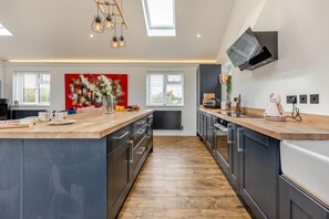 A modern kitchen with a central island, built-in appliances, and a large window.