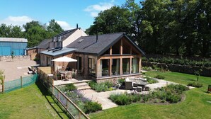 Ein modernes Haus mit Terrasse, Essbereich und Garten.