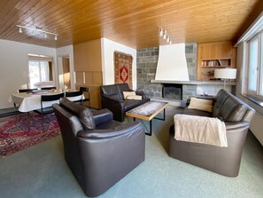 A modern living room with leather sofas, a coffee table, a fireplace, and a dining area with a table and chairs. - Haus Montana 3/7 Appartement/Fewo,   5-Bettwohnung by Interhome (Lenzerheide)