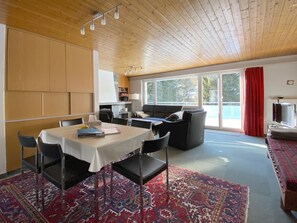 A room with a dining table, chairs, a sofa, and a television. - Haus Montana 3/7 Appartement/Fewo,   5-Bettwohnung by Interhome (Lenzerheide)