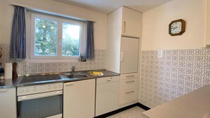 Una cucina compatta con una finestra, un lavello, un fornello e un frigorifero.