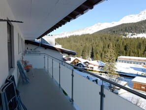 A balcony with a view of snow-covered mountains and a forested area. - Haus Montana 3/7 Appartement/Fewo,   5-Bettwohnung by Interhome (Lenzerheide)