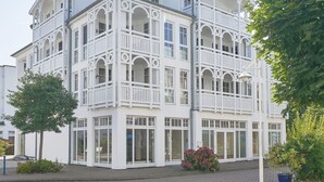 En byggnad med flera våningar, balkonger, stora fönster och en entré som är belagd med tegelstenar.