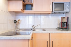 A kitchen with a stainless steel sink, a microwave, and a coffee maker. - Komfortable Ferienwohnung im Seepark Sellin (Sellin)