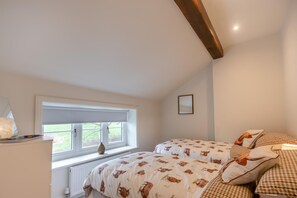 A bedroom with two beds, a window, a radiator, and a wooden ceiling beam. - 3 Bed in Bispham (oc-f34979) (Bispham)