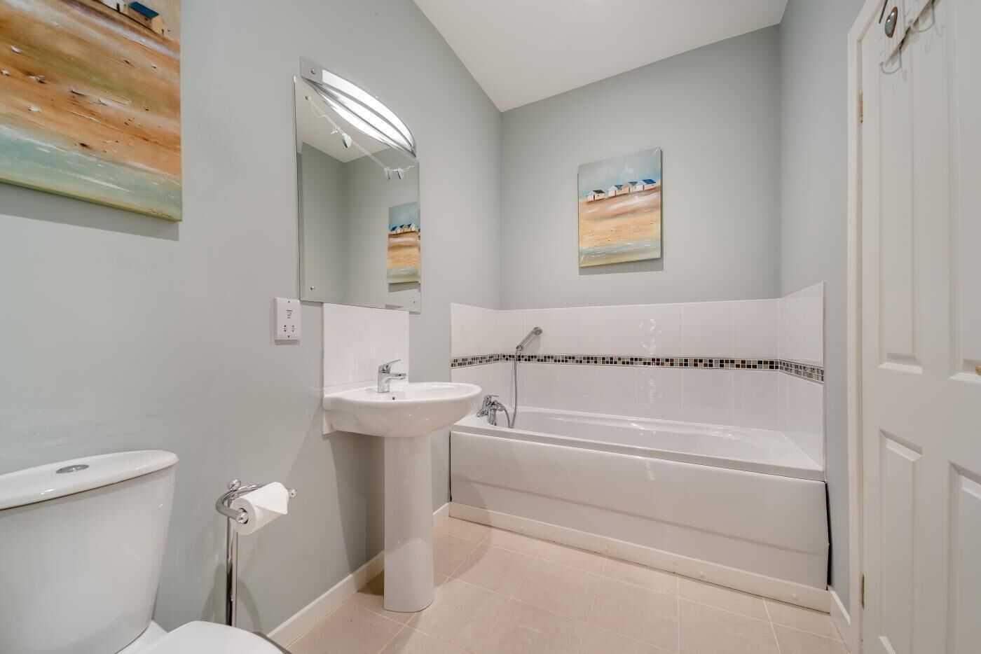 Een badkamer met een bad, een wastafel en een toilet.