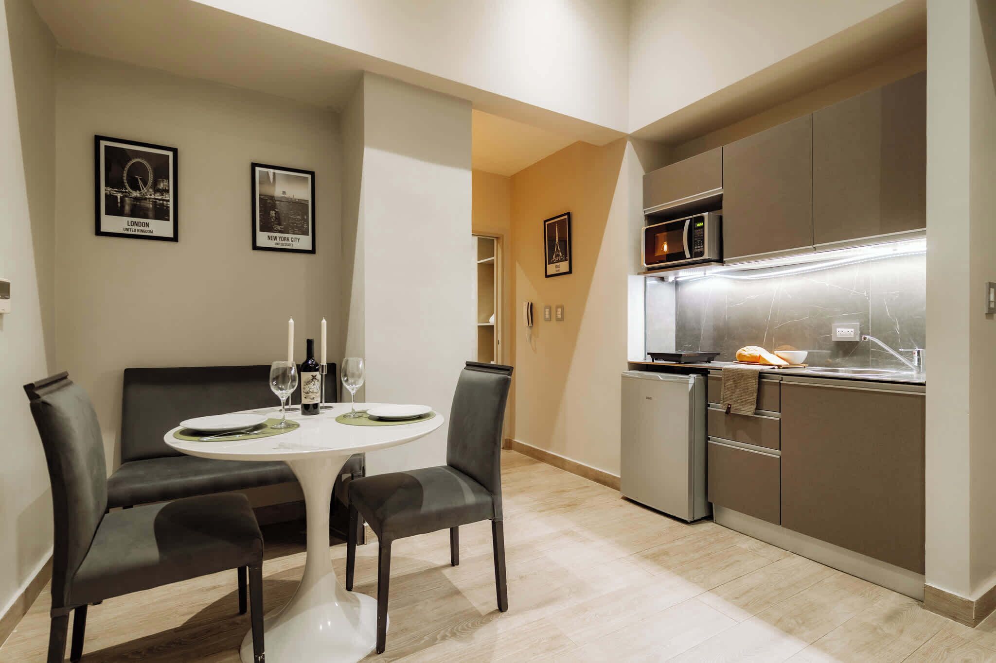 Una cocina compacta con microondas, refrigerador y una pequeña encimera.