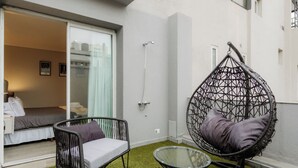 A room with a bed, a hanging chair, a glass table, and a shower. - Hestia en Cochabamba Boutique (Buenos Aires)