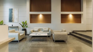 A modern lobby with a sofa set, a coffee table, and a potted plant. - Hestia en Cochabamba Boutique (Buenos Aires)