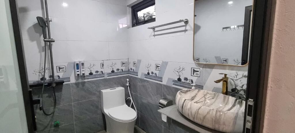 A bathroom with a toilet, bidet, and shower.