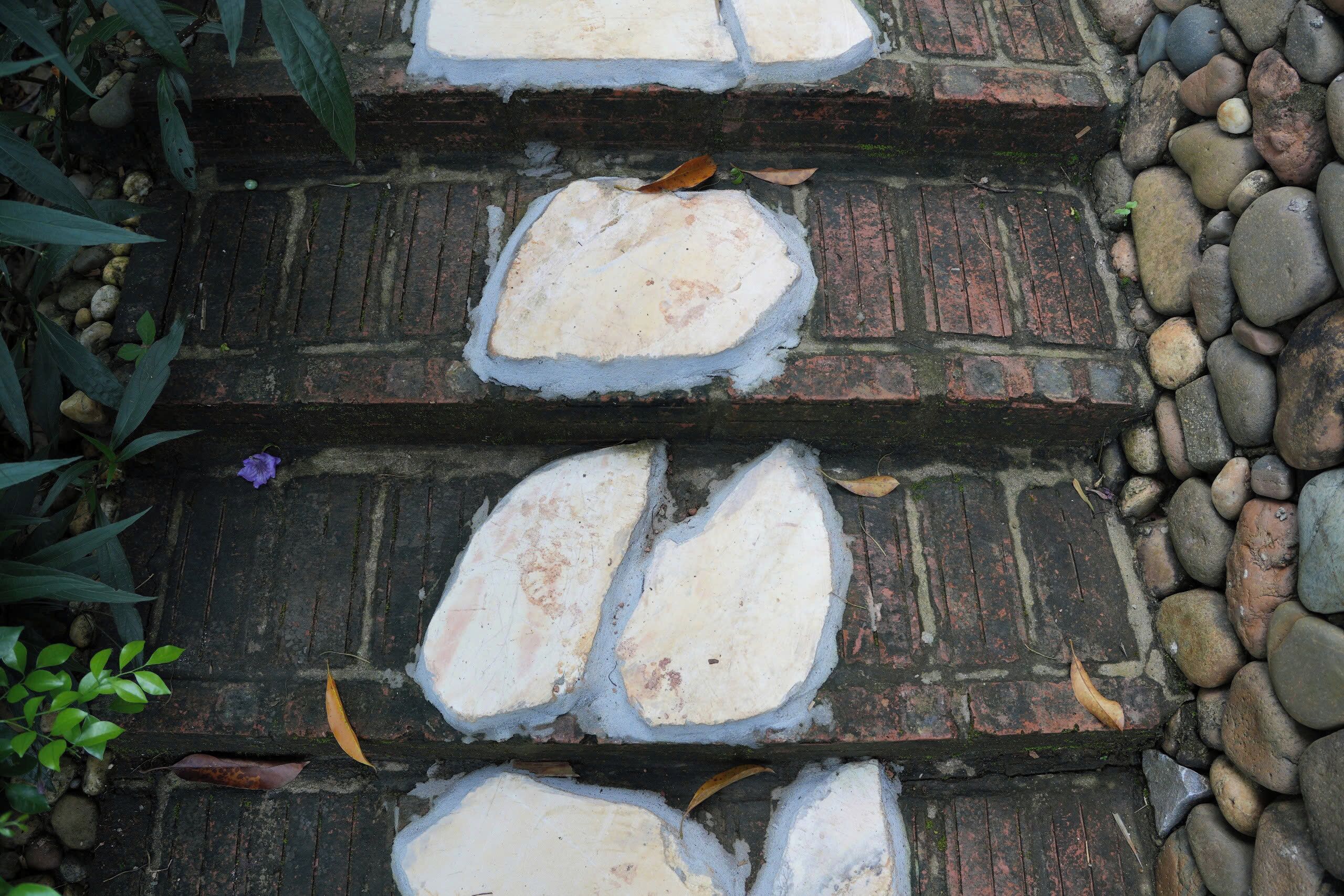 A set of stone steps with a brick wall on one side and a stone border on the other.