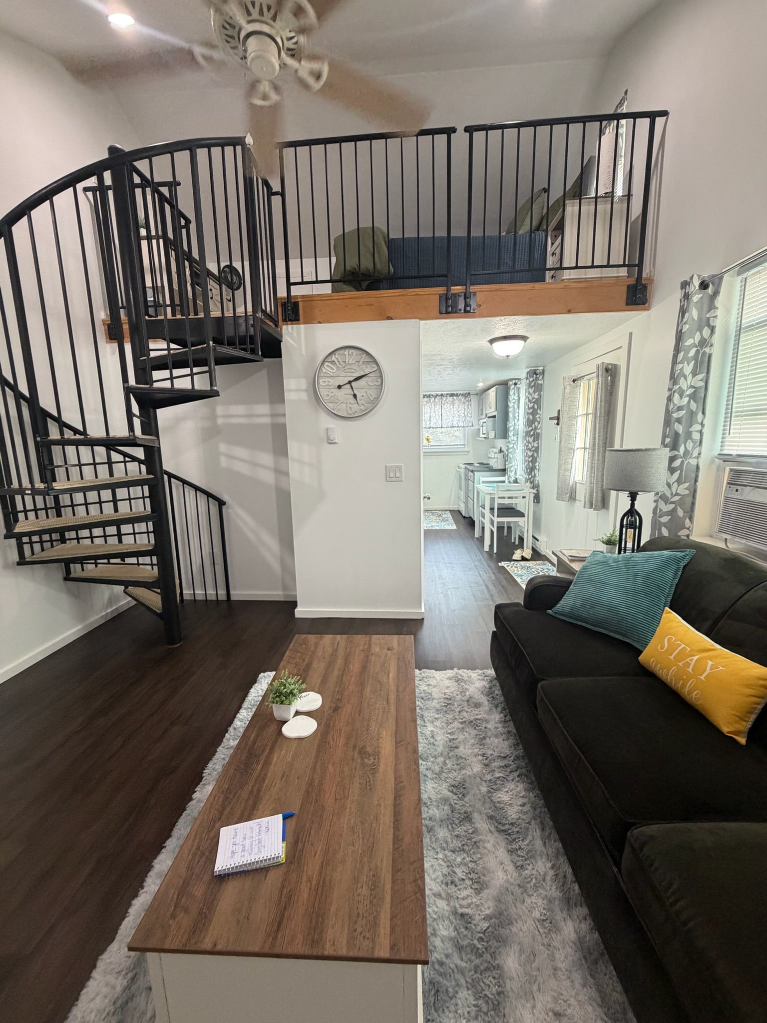 Ein zeitgemäßer Wohnraum mit Treppe, Essbereich und einer gemütlichen Sitzecke inklusive Sofa und Couchtisch.
