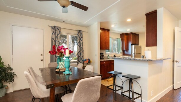 A modern kitchen with wooden cabinets, a central island, and bar stools. - Prime Location Near Gaylord Resort & Bayfront (Chula Vista)