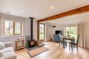 Una habitación acogedora con chimenea, una mesa de comedor con sillas, un sofá y un televisor.