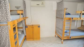 Un dormitorio con literas, un armario y unidad de aire acondicionado con conexión Wi-Fi.