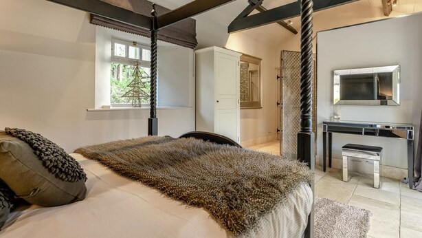 Ein Schlafzimmer mit einem Bett, einem Schreibtisch und einem Spiegel.