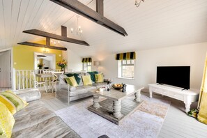 Ein geräumiges Wohnzimmer mit einer Couch, einem Couchtisch und einem Fernseher.
