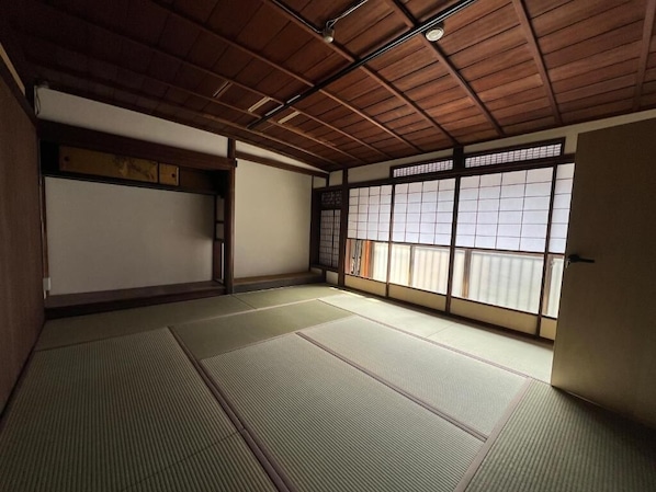A traditional Japanese room with tatami flooring, sliding doors, and a wooden ceiling. - HOBOIE Guest House (Tsuruga)
