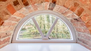 Um quarto com arco de tijolos e janela semicircular.