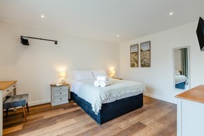A bedroom with a bed, bedside tables, a desk, and a mirror. - 4 Bed in Otterden (oc-d36009) (Otterden)