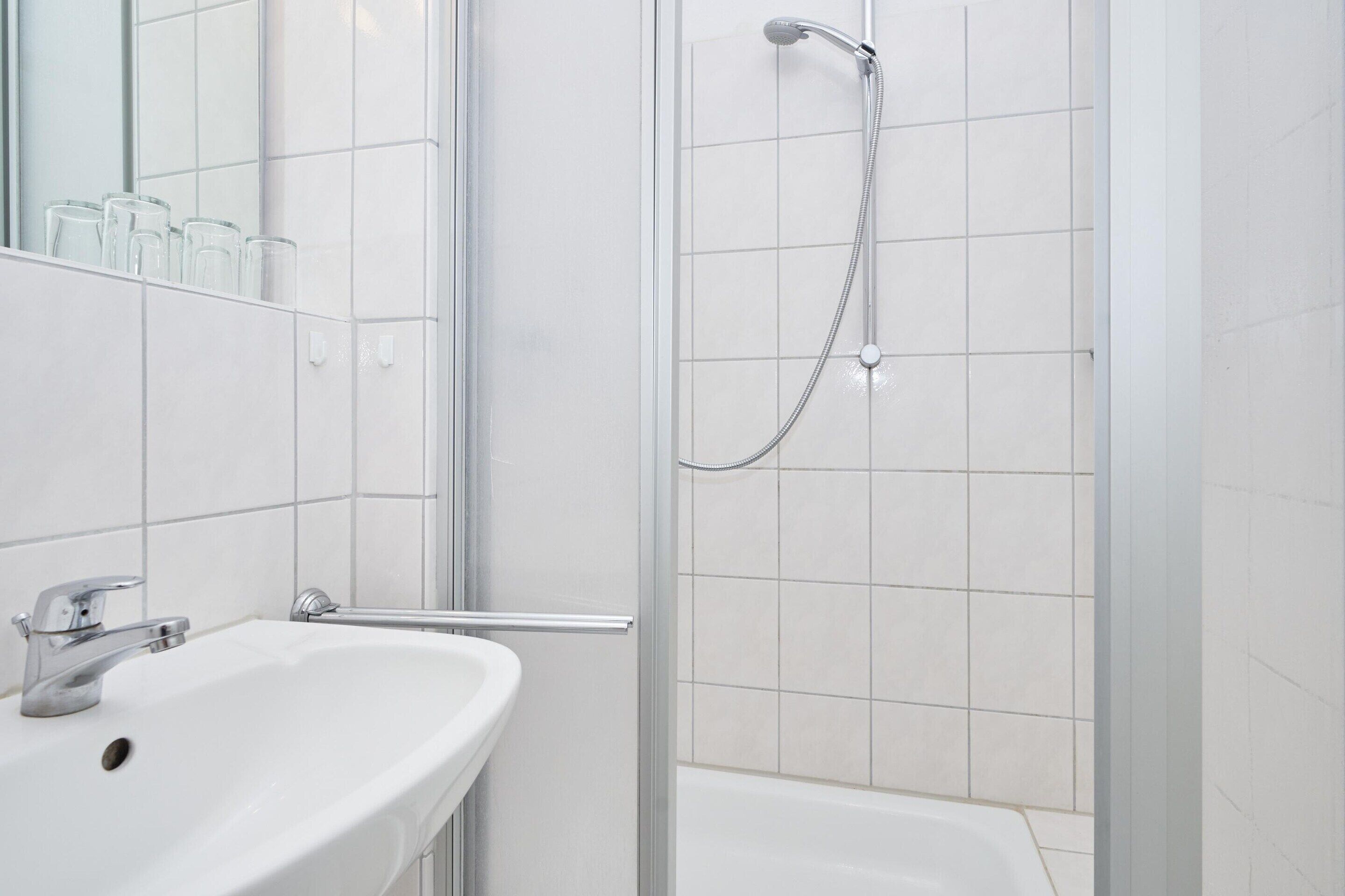 A bathroom with a white sink, a glass shower enclosure, and a bathtub.
