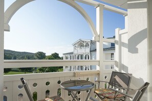 A balcony with a table and chairs, a view of a white building, and a clear sky. - Ferienwohnung in Sellin mit Balkon und Wlan (Sellin)