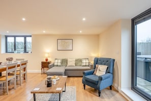 A modern living room with a sofa, armchair, dining table, and chairs. - 3 Bed in Feering (oc-hen6) (Feering)