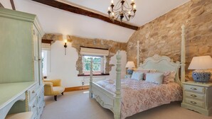 A bedroom with a four-poster bed, a dresser, a chair, and a stone wall. - 3 Bed in Wirksworth (oc-dchenm) (Hopton)