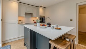 Een moderne keuken met een centraal eiland, ingebouwde apparaten en een dakraam.