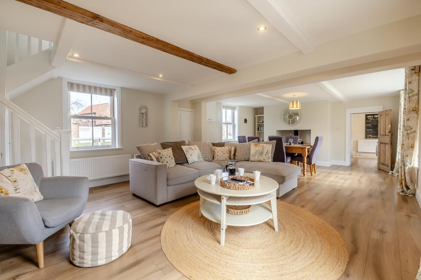 A spacious living area with a sofa set, a coffee table, and a dining table.