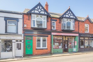 A row of shops with distinct architectural features, including a green door and a shop named 'Oriel Dawn'. - 2 Bed in Conwy (oc-t36008) (Conwy)