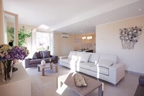 A modern living room with a sofa, a coffee table, and a decorative leaf centerpiece. - Villa Donagh sleeps 12, lake view & pool by Italian Apartments. (Ossuccio)