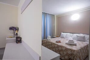 A hotel room with a bed, a bedside table, a lamp, and a window with curtains. - Villa Donagh sleeps 12, lake view & pool by Italian Apartments. (Ossuccio)