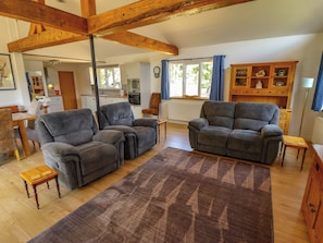 A living room with two grey sofas, a wooden coffee table, and a patterned rug. - 80 Pentney Lakes (King's Lynn)