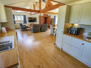 A spacious living area with a kitchen, wooden flooring, and a dining area with a table and chairs. - 80 Pentney Lakes (King's Lynn)